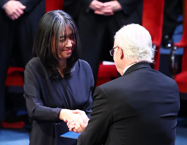 2024 노벨문학상 수상자인 한강 작가가 10일(현지시간) 스웨덴 스톡홀름 콘서트홀에서 열린 시상식에서 칼 구스타프 16세 스웨덴 국왕으로부터 노벨문학상 메달과 증서를 받고 있다. 연합뉴스